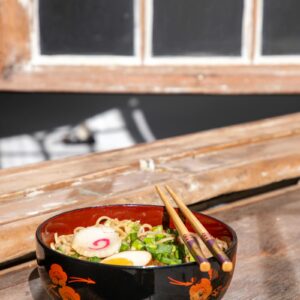 Ramen shoyu en bol noir, baguettes posées