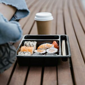 Sushi et boisson sur banc bois, ambiance détendue